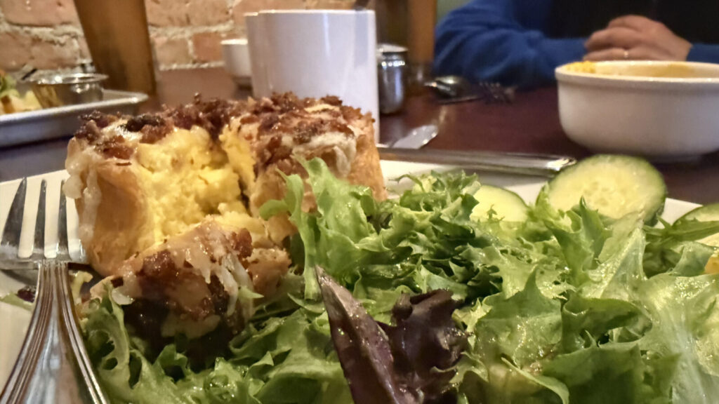 Quiche Lorraine and a crisp green salad sit gleaming on a plate at the Eagle Street Cafe.