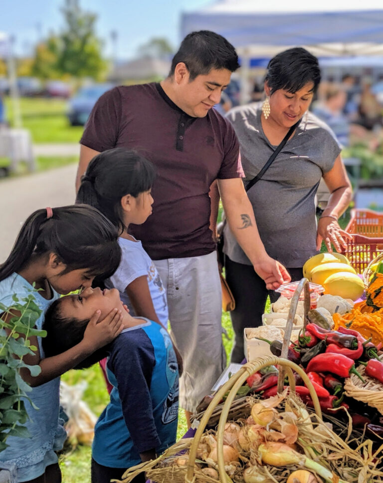 A local family look through locally grown produce at the Pittsfield Farmers Market. Press photo courtesy of Roots Rising