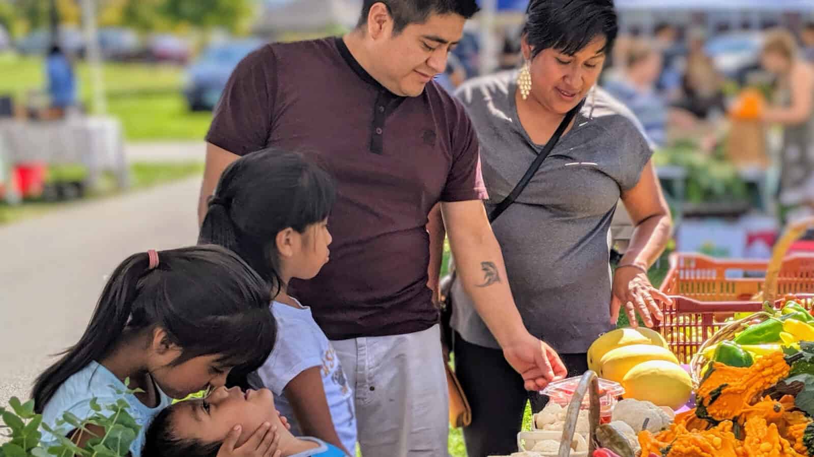 A local family look through locally grown produce at the Pittsfield Farmers Market. Press photo courtesy of Roots Rising