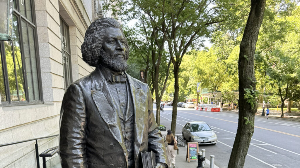 A bronze sculpture of Frederick Douglass looks across a city street at the New York Historical Society. Creative Commons courtesy photo