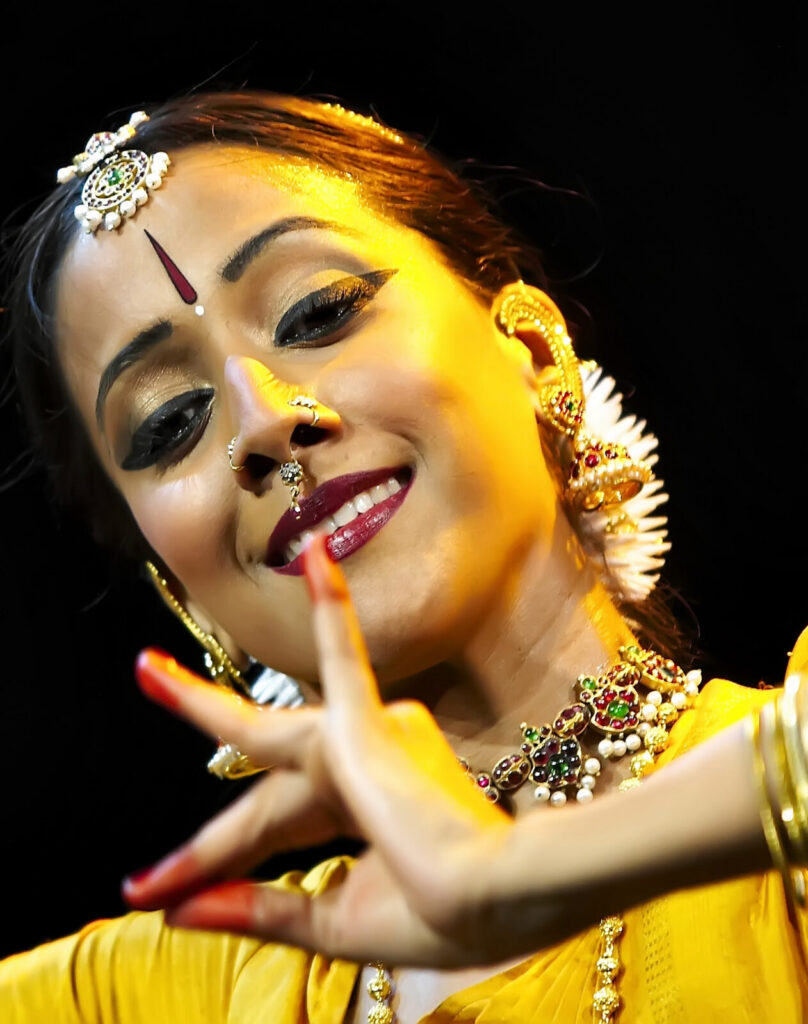 Internationally acclaimed Bharatanatyam dancer and choreographer Mythili Prakash, from Los Angeles, performs with expressive hands in a golden glow. Press photo courtesy of Jacobs Pillow Dance Festival